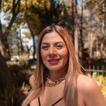 Portrait of a fashionable woman in a park, showcasing glam style under bright sunlight.